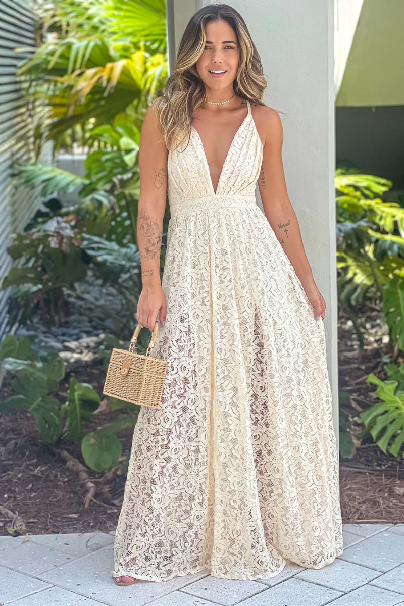 woman wearing cream lace v-neck maxi dress with cream bag